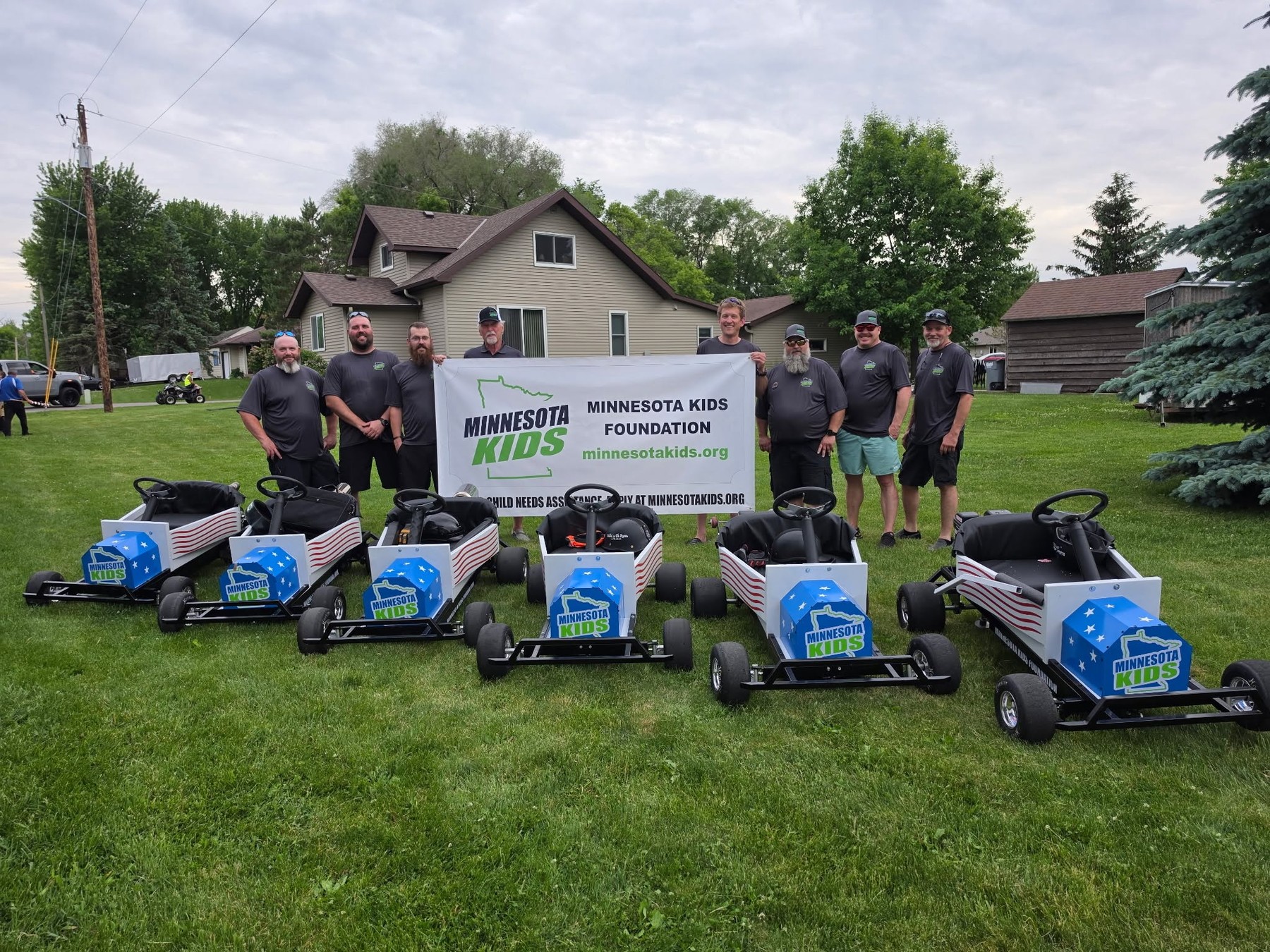 Minnesota Kids Foundation volunteers with branded parade carts and foundation banner